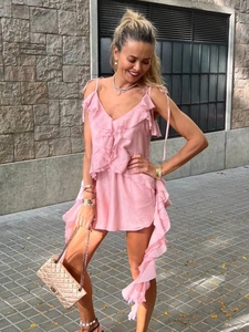 Detail of pink ruffled V-neck top with adjustable tie straps and layered chiffon fabric
