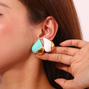 Macro view of mint green and white enamel heart earrings in 18K gold-plated finish