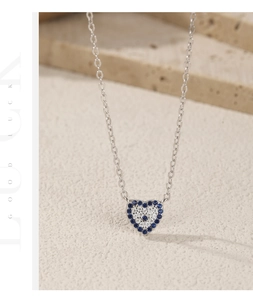 Macro detail of S925 silver heart necklace with blue and white pavé-set crystals