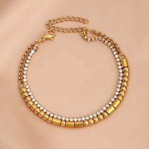 Detail of gold double-layer bracelet with Cuban chain, pavé crystals and round beads