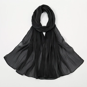 Detail eines schwarzen Schals mit feiner Plisseestruktur und leichtem Chiffon-Stofffall