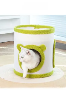 Detalle de rascador cilíndrico para gatos con borde de felpa verde y entrada de gato