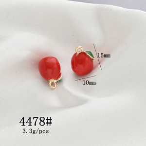 Detailed macro view of red enamel apple charms with 15x10mm size and 3.3g weight