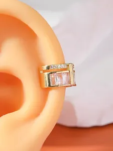 Detailed close-up of gold-plated ear cuff with rectangular zircons on ear model