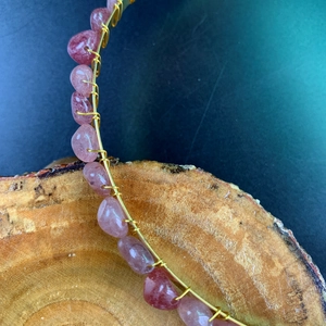 Macro detail of handmade gold wire crown with natural pink crystal stones