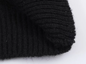 Vue macro montrant la texture douce et les fibres du pull et de la jupe en maille noire