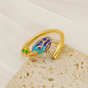 Detail of leaf-shaped open ring with vibrant multi-color enamel on stone background