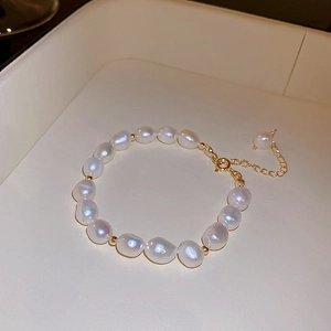 Detailed macro view of baroque freshwater pearls with golden metal spacers and lobster clasp