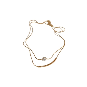 Minimalist double-layer gold necklace featuring a white pearl and textured metal tube pendant