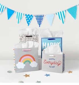 Set of four gift bags with rainbow and floral designs for party celebrations