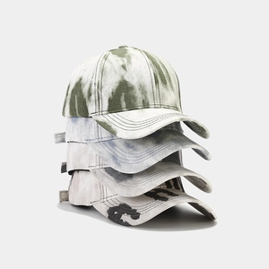 Empilement vertical de quatre casquettes de baseball tie-dye en vert, bleu et gris