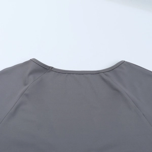 Gros plan sur le décolleté en V et la couture d'une robe en maille ajustée grise