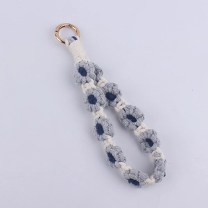 Close-up of handmade crochet daisy flower wrist strap with polished golden metal ring