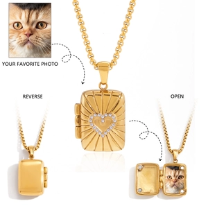 Detail of vintage tarot-style gold pendant necklace featuring an opening photo locket with heart