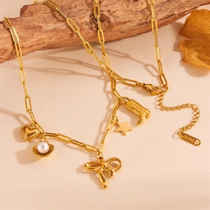 Close-up of gold stainless steel shell necklace with heart, star and boot charms