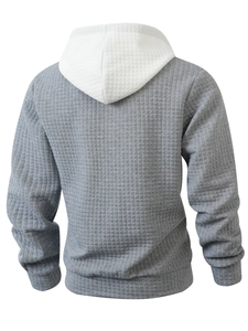 Detail of grey waffle knit hoodie featuring a contrast white hood and textured fabric