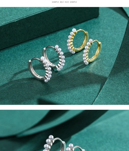 Detail of gold and silver hoop earrings with round white pearl inlays on green card