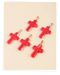 Detailed view of five red glass cross pendants with elegant gold hanging loops