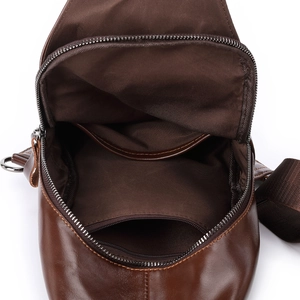 Close-up of leather chest bag interior showing large capacity pockets and brown fabric lining