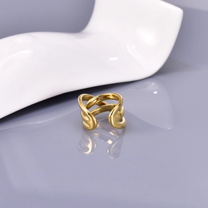 Detail of multi-layer crisscross gold ring with high-polish finish on reflective base