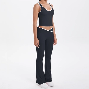Détail de la taille croisée en V et des liserés blancs sur le pantalon de yoga évasé noir