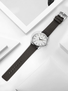Detailed macro of minimalist quartz watch with silver brushed case and date window display