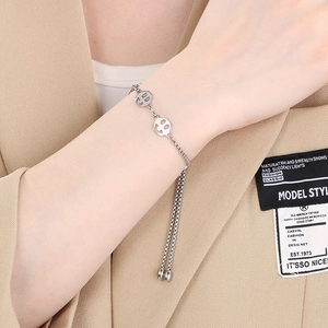Detailed shot of silver box chain bracelet with hollow smiley face and adjustable tassels