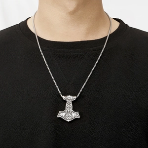 Detailed view of silver Viking Mjolnir hammer pendant with Valknut engravings worn by model