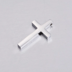 Polished silver stainless steel cross pendant on a brushed metal surface