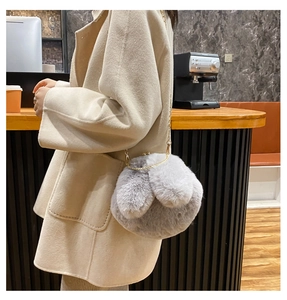 Detail of plush grey bunny ears handbag with gold metal clasp and chain strap