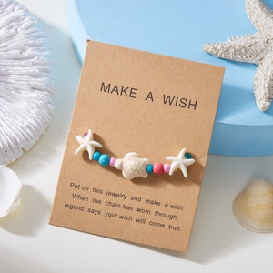 Detail of starfish and turtle charms on a beaded bracelet with a 'Make a Wish' card