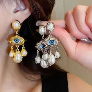 Vintage eye design earrings with blue beads and teardrop faux pearls in gold and silver