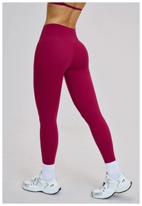 Detailed macro view of high-waisted burgundy yoga pants with elastic matte fabric