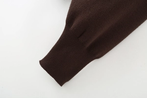 Detailed view of the ribbed cuffs on a dark brown knitted long sleeve sweater