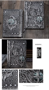 Close-up of vintage silver notebook with 3D embossed knight, sword and shield texture
