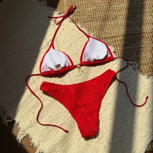 Detail of red bikini featuring textured seersucker fabric and starfish pearl pendant