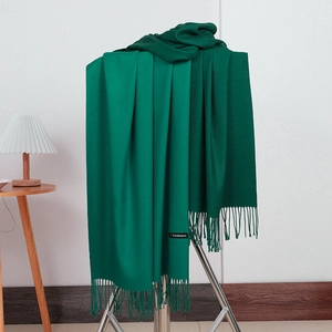 Detail shot of forest green cashmere scarf featuring a soft texture and delicate fringes