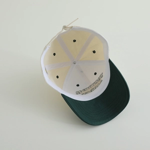 Detail of baby baseball cap interior with reinforcement tapes and breathable metal eyelets