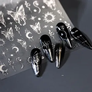 Detailed silver metallic nail art stickers featuring butterfly and moon motifs on black nails