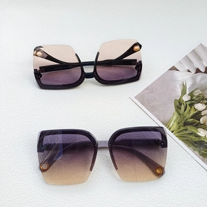 Detail view of stylish gradient purple-orange semi-rimless sunglasses with floral accents