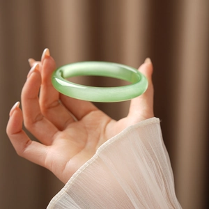 Detail of light green cat eye stone bangle with translucent fibrous texture and oily luster