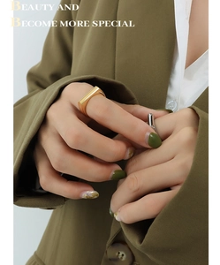 Close-up of geometric gold rectangular ring and irregular silver band on model