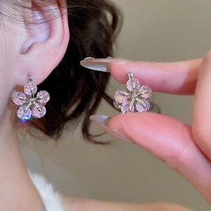 Detail of pink zircon flower earrings on ear showing delicate sparkle and craftsmanship