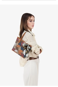 Detail view of large tote bag with geometric patchwork and silk scarf decor on model