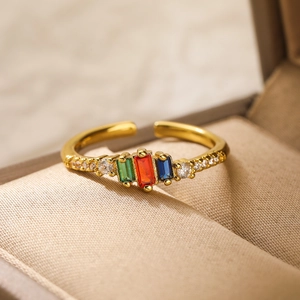 Detail of adjustable gold plated ring with colorful rectangular crystals in a jewelry box