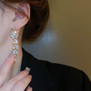 Silver drop leaf tassel earrings with sparkling zircon on model in close-up view