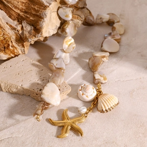 Detail of beaded shell necklace with starfish charms on natural rock and wood