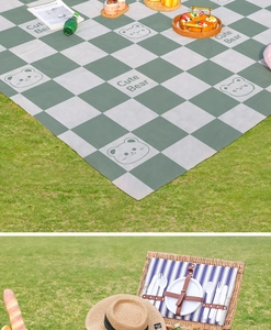 Macro detail of waterproof picnic mat with bear pattern and classic green-grey plaid