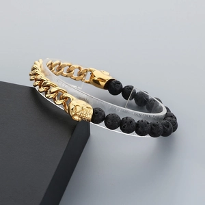 Detail of golden skull bead, Cuban links and black volcanic lava beads on a men's bracelet