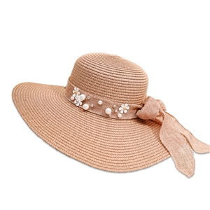 Detailed view of women's straw sun hat featuring elegant flower and pearl bow accents
